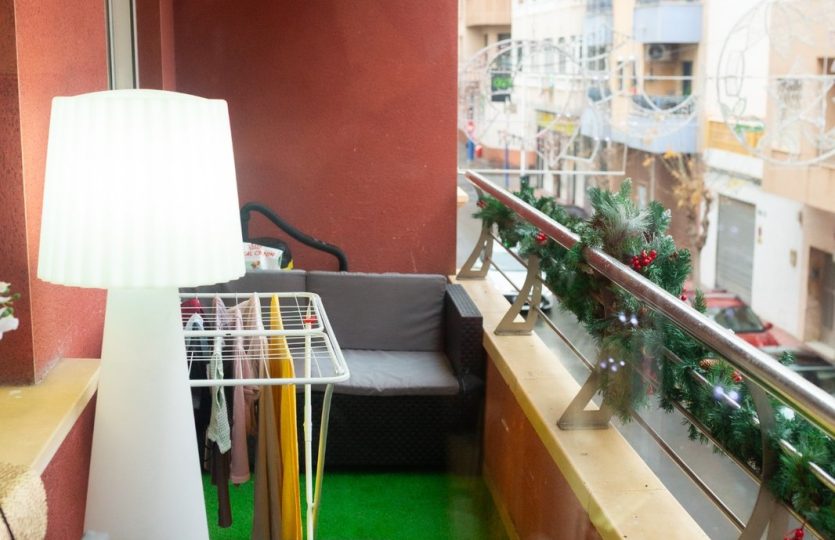 Rent in Torrevieja – Modern 2 Bedroom Apartment with Balcony in the city centre featuring a spacious private terrace with outdoor seating and artificial grass.