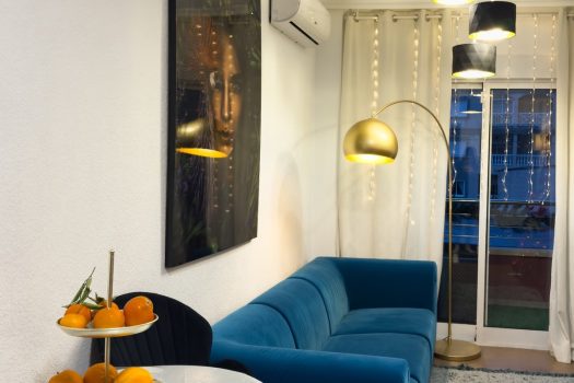 Rent in Torrevieja – Spacious Living Room with dining area, modern sofa, decorative lighting, Christmas tree, and access to the balcony.